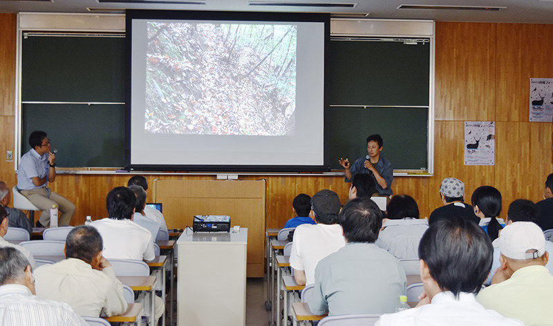 千松信也さん(壇上右)が山での体験を基に狩猟の魅力を伝えた=岡山大津島キャンパスで、益川量平撮影