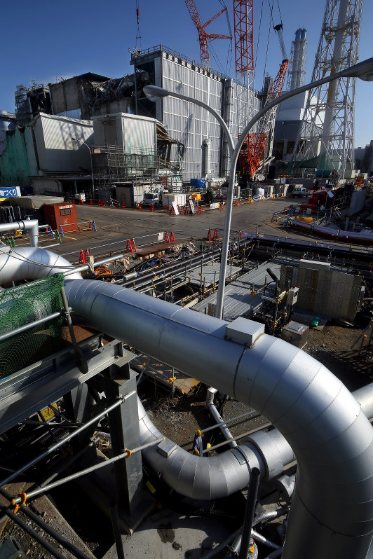 原子炉建屋を囲むように走る凍土遮水壁の凍結管(手前)。奥左は3号機、同右が4号機=福島第1原発で2016年2月、森田剛史撮影