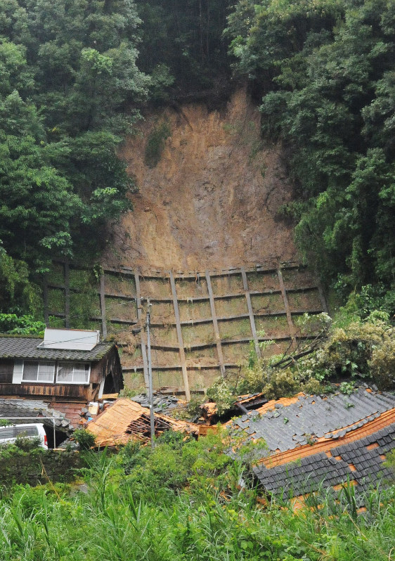 土砂崩れに巻き込まれた住宅(右)。1人が意識不明になった=鹿児島県姶良市蒲生町北で2016年6月28日午後4時46分、田中韻撮影