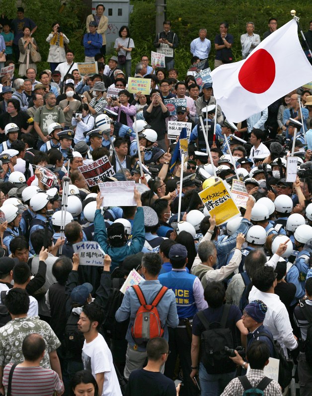 警察官が割って入る中、もみ合う集会参加者と反対する市民ら=川崎市で2016年6月5日、小出洋平撮影