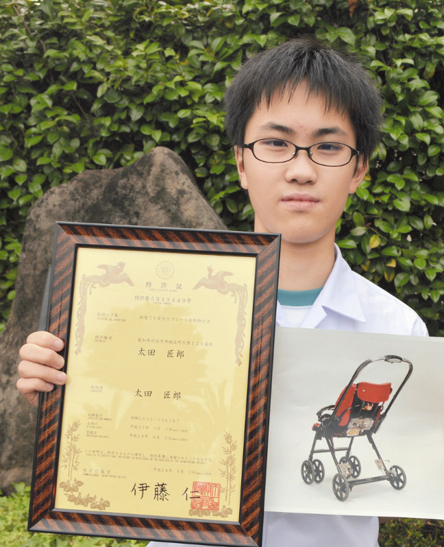特許証(左)とベビーカーの写真を手にする太田匠郎さん=愛知県刈谷市の朝日中で