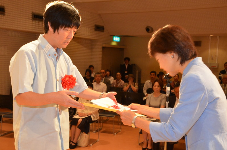 丸山豊記念現代詩賞実行委の浜崎会長(右)から賞状を受け取る白井さん