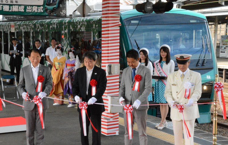 新型車両の出発を前に、関係者がテープカットに臨んだ=JR秋田駅で2016年7月16日、池田一生撮影