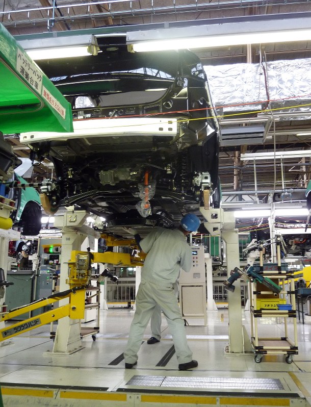 三菱自動車岡崎工場の生産ラインで、車体を組み立てる作業員ら=2014年6月、和田憲二撮影