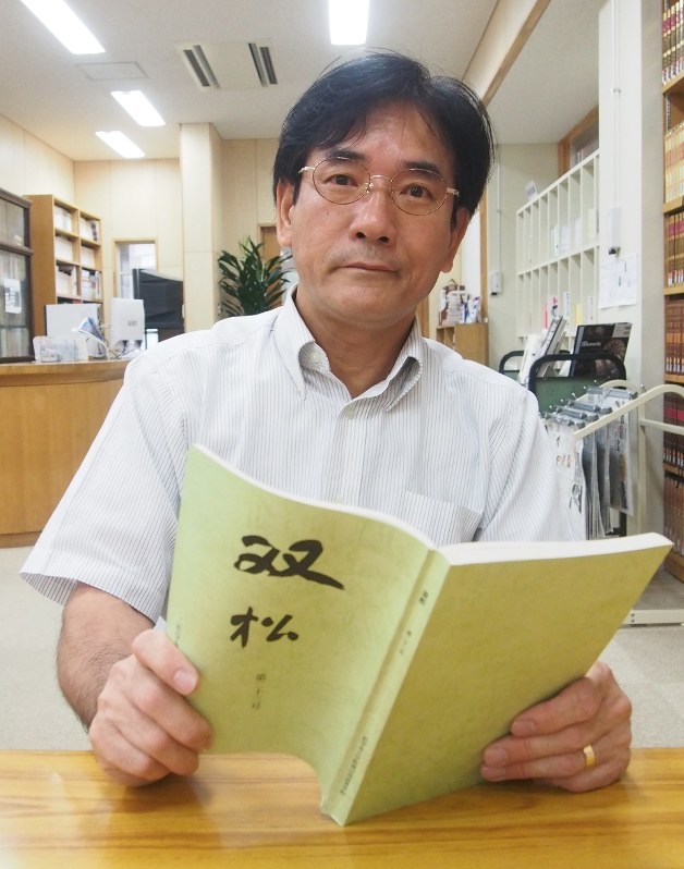村田さんの作文が掲載された文集を手に芥川賞受賞を喜ぶ二松学舎大学付属柏高校の野島淳一教諭