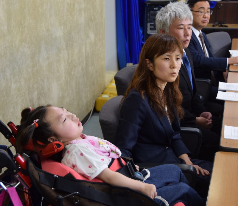 高橋心音ちゃん(手前)を伴い記者会見する母亜希子さん(左から2人目)と父歩さん(同3人目)=東京・霞が関の厚生労働省で2016年7月21日午後1時27分、伊藤直孝撮影