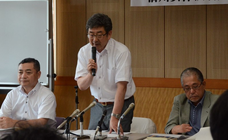 原告団の集会で提訴の意義を説明する又坂常人・原告団長(中央)=長野市の県弁護士会館で