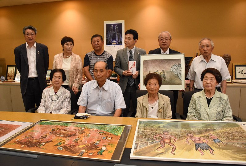 「原爆被爆惨状絵図」を寄贈した県被爆者手帳友の会の会員ら=今野悠貴撮影