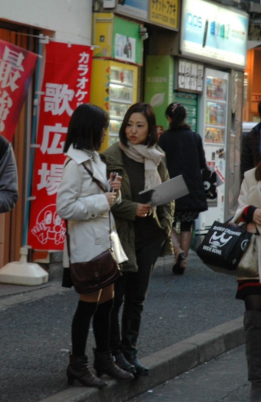 繁華街の路地にたたずむ女の子に声をかける橘ジュンさん(右)。あてもなく上京してきた子どもに出会うことも少なくない=東京都渋谷区で、黒田阿紗子撮影