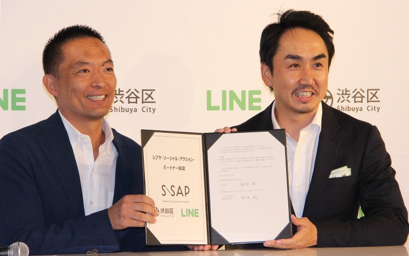 協定締結の署名をした東京都渋谷区の長谷部健区長(左)とLINEの出沢剛社長=2016年8月3日、岡礼子撮影