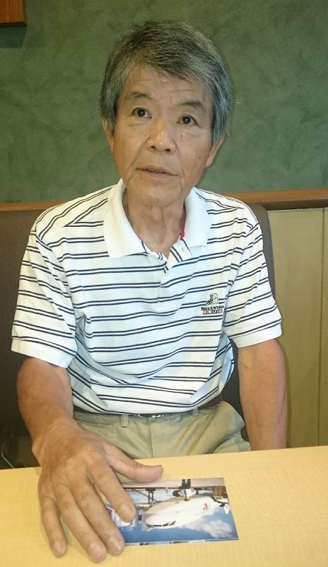 機長時代の写真を手に、かつての記憶をたどる佐藤進さん