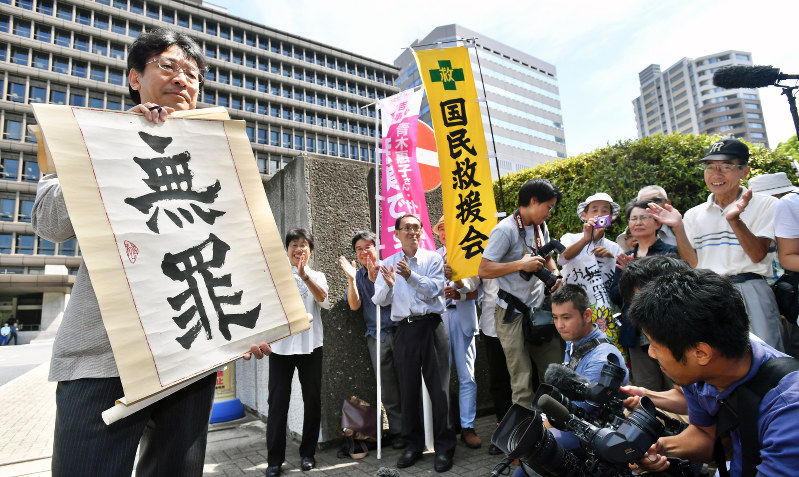 青木恵子さんの無罪判決を知らせる垂れ幕を掲げる弁護士=大阪市北区で2016年8月10日午前10時5分、小関勉撮影