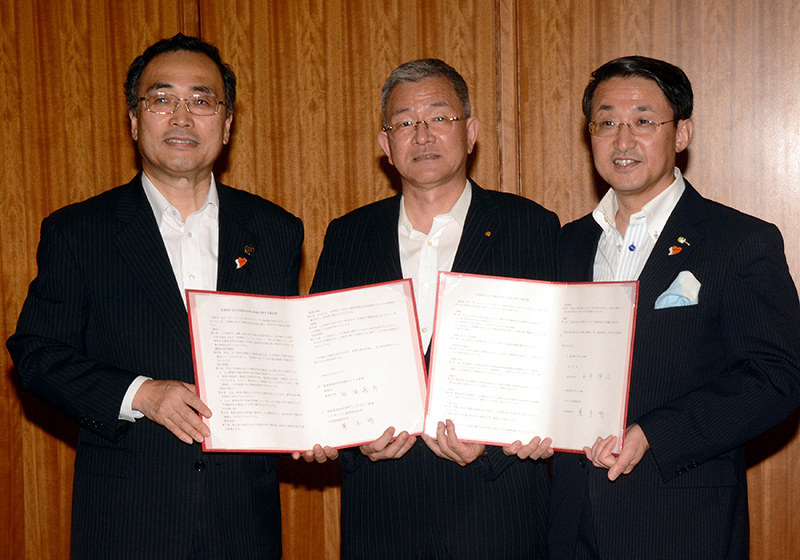 協定書を掲げるマルサンアイ鳥取の兼子明社長(中央)と平井伸治知事(右)、深沢義彦・鳥取市長=鳥取県知事公邸で、李英浩撮影