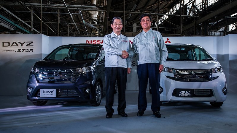 共同開発した軽自動車の前で握手する三菱自動車の益子修社長(右)と日産の志賀俊之最高執行責任者(肩書きはいずれも当時)=2013年5月20日、松倉佑輔撮影