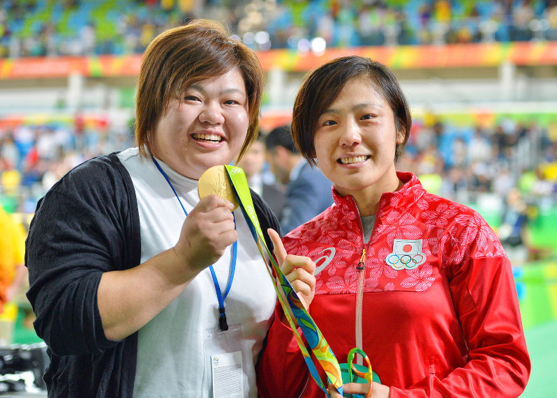 柔道女子70キロ級を制した田知本遥(右)の金メダルを手に笑顔の姉愛さん=リオデジャネイロで10日、ゲッティ共同