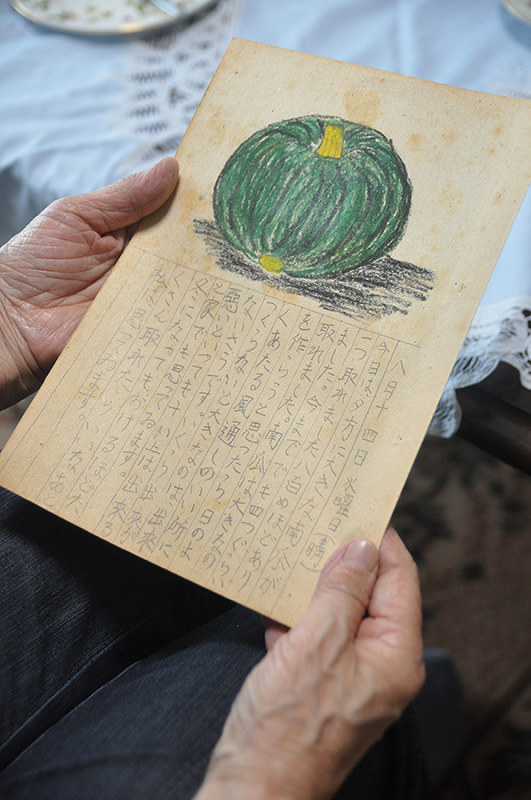 70年前に描いた絵日記を手にする山中和子さん。8月14日のページには、大きなカボチャが描かれていた=岡山県赤磐市で、花澤茂人撮影