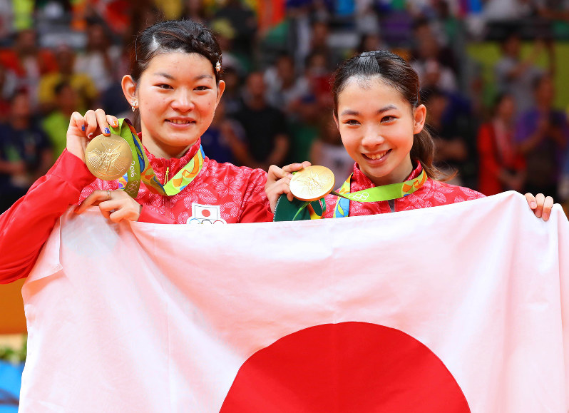 女子ダブルス決勝で金メダルを獲得し、日の丸を手にメダルを見せる高橋礼華(左)、松友美佐紀組=リオデジャネイロのリオ中央体育館で2016年8月18日、小川昌宏撮影