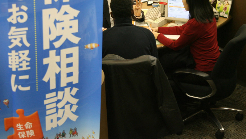 保険商品について説明する銀行員=2007年12月、佐々木順一撮影