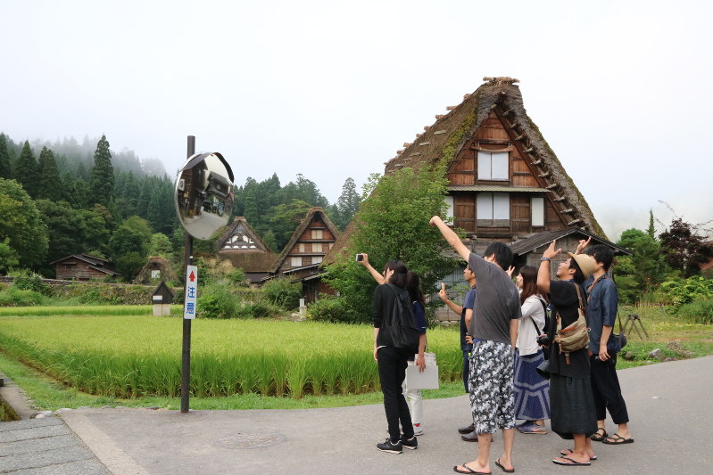 初対面同士でも共通の旅の目的が距離を縮める=岐阜県白川村の白川郷合掌造り集落で池乗有衣撮影