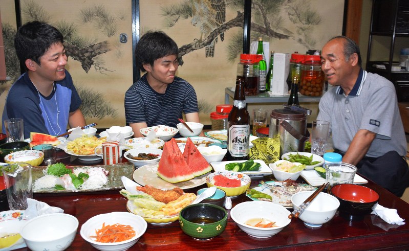 農家民宿を営む武藤正敏さん(右)と話しながら、地元野菜の手料理を楽しむ大東文化大の学生たち=福島県二本松市の民宿「田ん坊」で2016年9月8日、杉直樹撮影