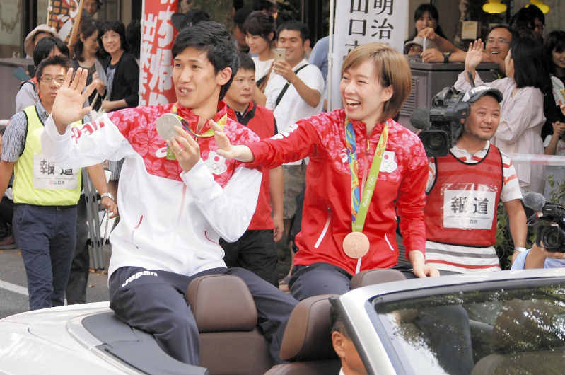 笑顔で声援に応える吉村選手(左)と石川選手