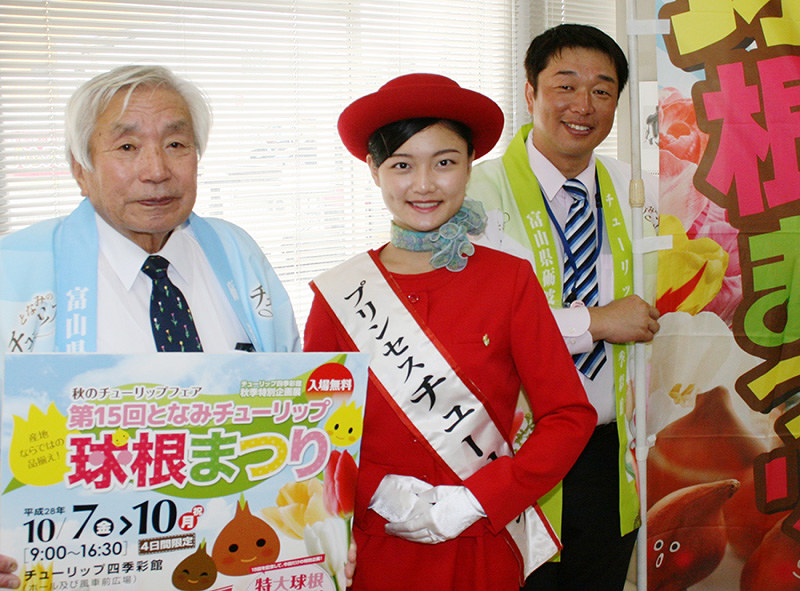 「第15回となみチューリップ球根まつり」に多くの来場を呼びかけるプリンセスチューリップの花車朱里紗さん(中央)ら=富山市で、堀川剛護撮影
