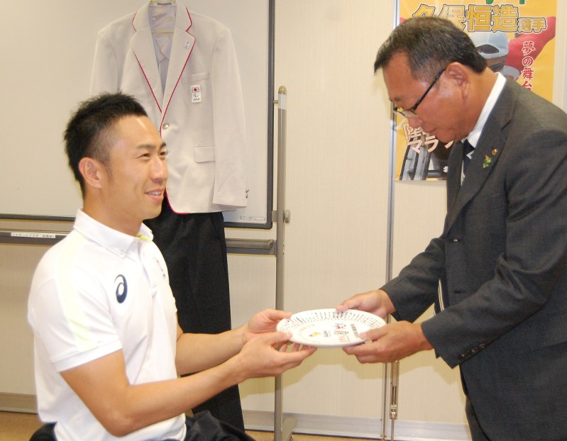 リオデジャネイロ大会出場記念の皿を土谷町長(右)に手渡す久保選手=美幌町で