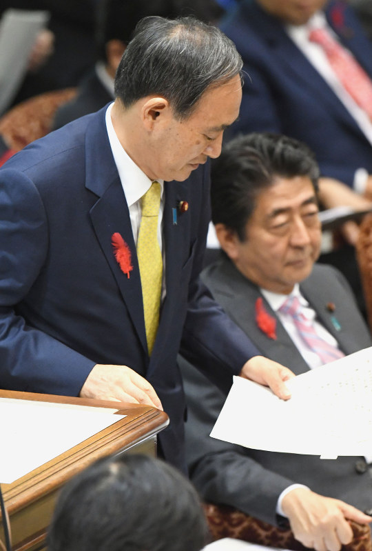 参院予算委員会で小池晃共産党書記局長による自らの政治資金収支報告書記載の領収書についての質問で答弁に立つ菅義偉官房長官。右は安倍晋三首相=国会内で2016年10月6日午後2時25分、藤井太郎撮影