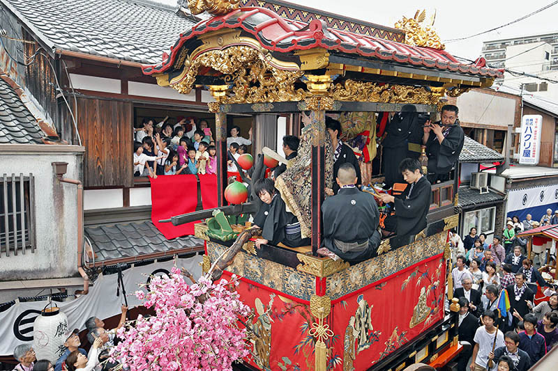 大津祭で古い街並みを巡行する西王母山。二階家の子供たちがちまきに飛びついていた=大津市内で、三村政司撮影