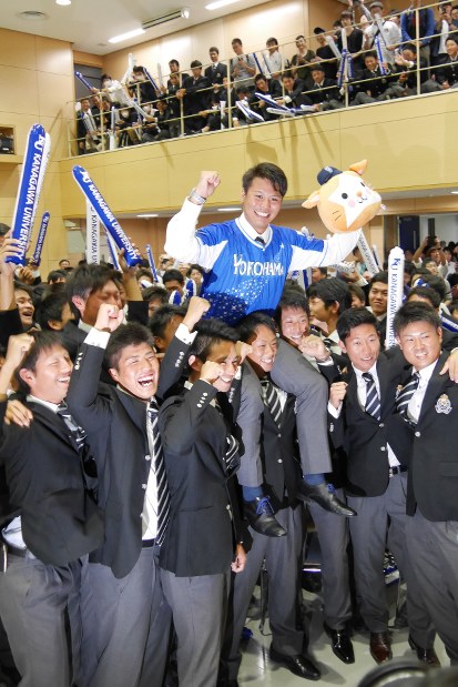 ベイスターズのユニホームに袖を通し、神奈川大硬式野球部のチームメートに肩車で祝福される浜口遥大投手
