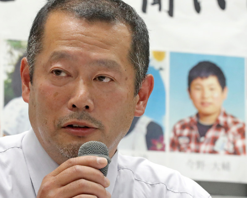 記者会見で質問に答える今野浩行さん。会場には大川小で亡くなった大輔さん(右奥)の写真も飾られていた=仙台市青葉区で2016年10月26日午後4時13分、喜屋武真之介撮影