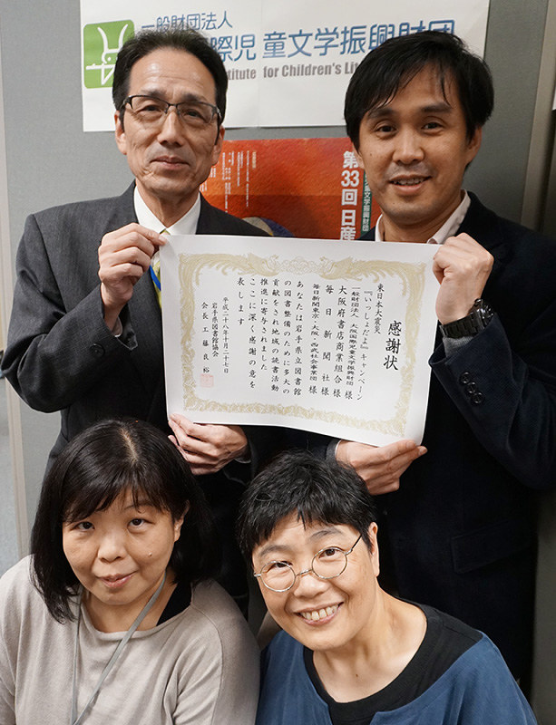 岩手県図書館協会から贈られた感謝状を手にする大阪国際児童文学振興財団の職員たち=東大阪市荒本北1で、反橋希美撮影