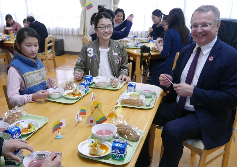 児童に囲まれながら給食を楽しむリトアニアのメイルーナス駐日大使(右)