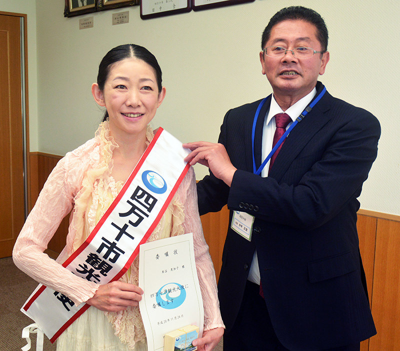 観光大使のタスキを中平市長(右)から掛けてもらうホンヤさん=高知県四万十市役所で、真明薫撮影
