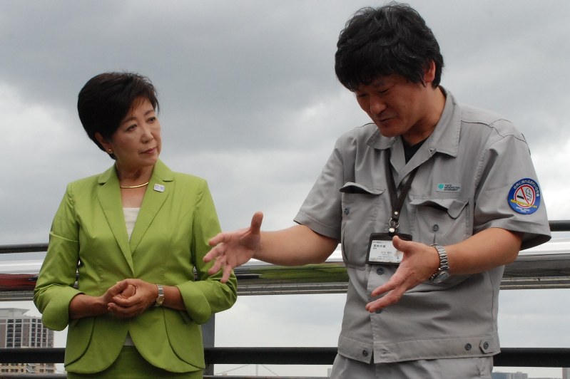 築地市場の駐車場の屋上で職員から説明を受ける小池知事(左)=中央区の築地市場で2016年8月16日午後1時33分、川畑さおり撮影