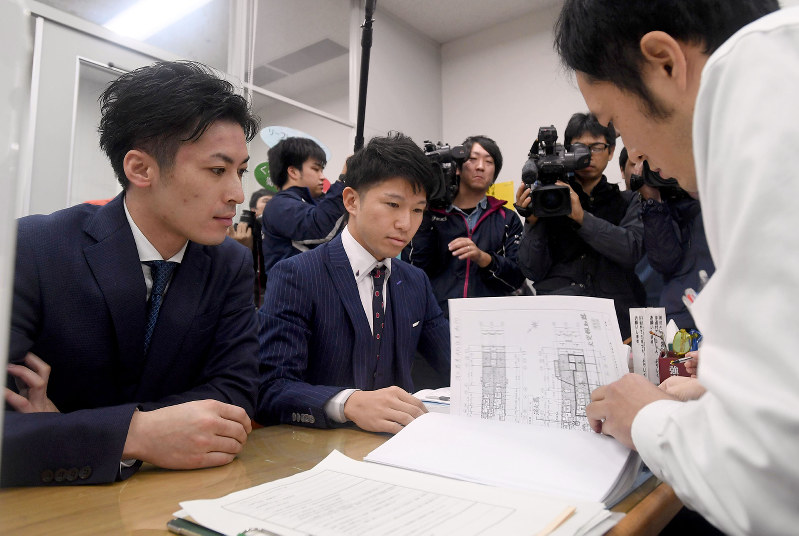 民泊の営業許可を申請する宿泊業者(左)=福岡市博多区で2016年12月1日午前9時5分、津村豊和撮影