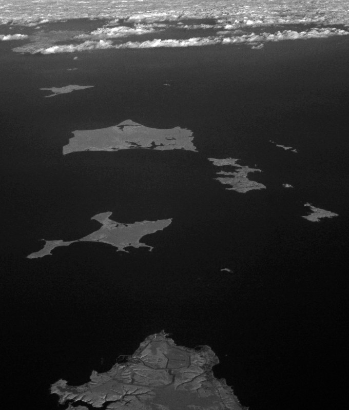 根室半島上空から見た歯舞群島(中央)。手前は北海道根室市の納沙布岬。左奥は色丹島=北海道根室市で2016年12月3日本社機「希望」から徳野仁子撮影(赤外線カメラ使用)