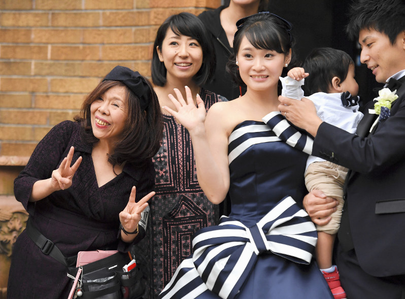 心の支えとなったドレスをまとう川瀬亜沙華さん(中央右)と、記念撮影に臨む松居エリさん(左端)=東京都台東区で、内藤絵美撮影