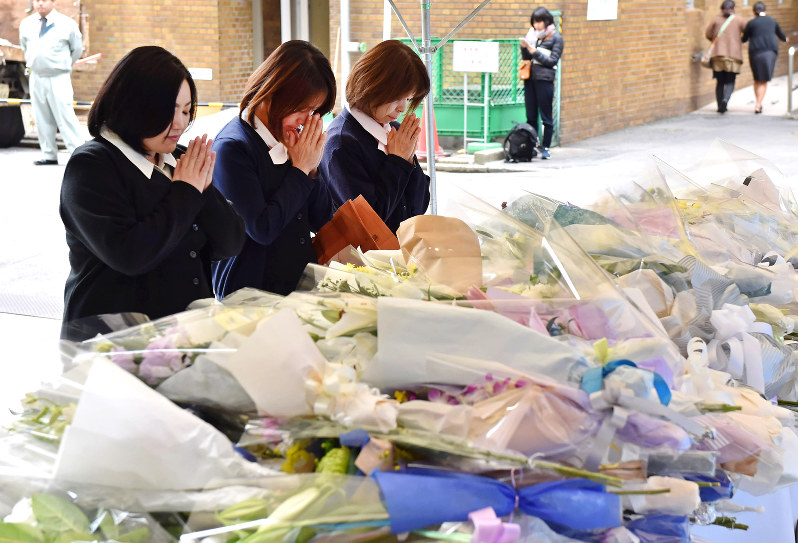 事故現場前に設けられた献花台に花を供え、手を合わせる人たち=福岡市博多区で2016年12月6日午前10時10分、須賀川理撮影