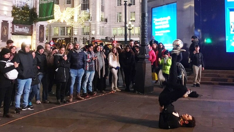 ショッピング街では、通行人が足を止めて大道芸人のパフォーマンスにくぎづけ=英ロンドンで2016年11月、三沢耕平撮影