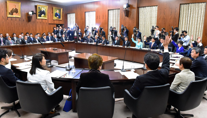 参院内閣委員会で「統合型リゾート(IR)整備推進法案」の修正案の採決があり、賛成のため挙手する自民党議員(奥)や公明党議員(手前右から3人目)らと反対のため挙手をしない民進党などの議員ら(手前)=国会内で2016年12月13日、川田雅浩撮影