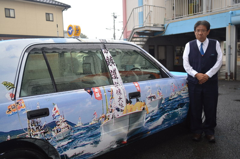 みあれ祭の海上パレードを写した写真を車体にプリントしたタクシー