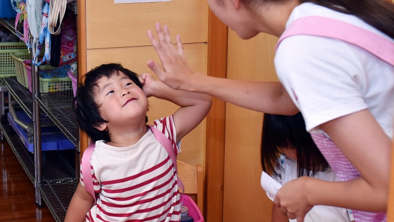 保育園の先生にバイバイする子供=関口純撮影