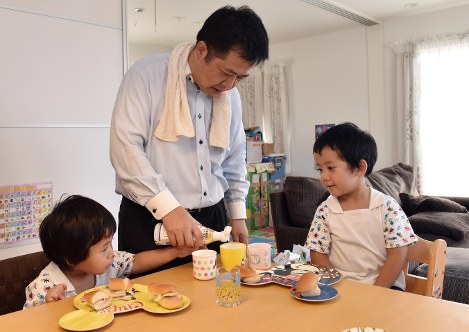 朝食を準備して子供に食べさせるお父さん=関口純撮影