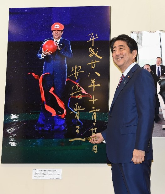 安倍首相：「報道写真展」を鑑賞 「マリオ」サイン | 毎日新聞