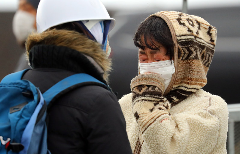 火災現場付近で知人と再会し、喜び合う女性=新潟県糸魚川市で2016年12月24日午前9時8分、小川昌宏撮影