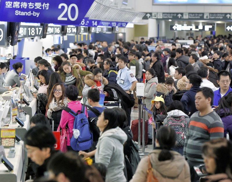 天候が回復して航空機の運航が再開されたものの、多くの人たちで大混雑する新千歳空港のチェックインカウンター=北海道千歳市で2016年12月24日、手塚耕一郎撮影