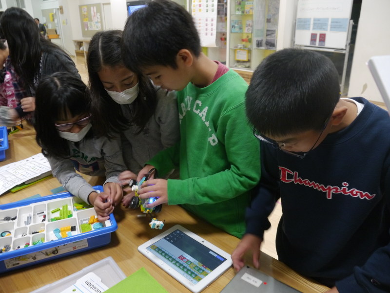 自作のレゴロボット教材をタブレット端末でプログラミングする子供たち=東京都杉並区立天沼小で
