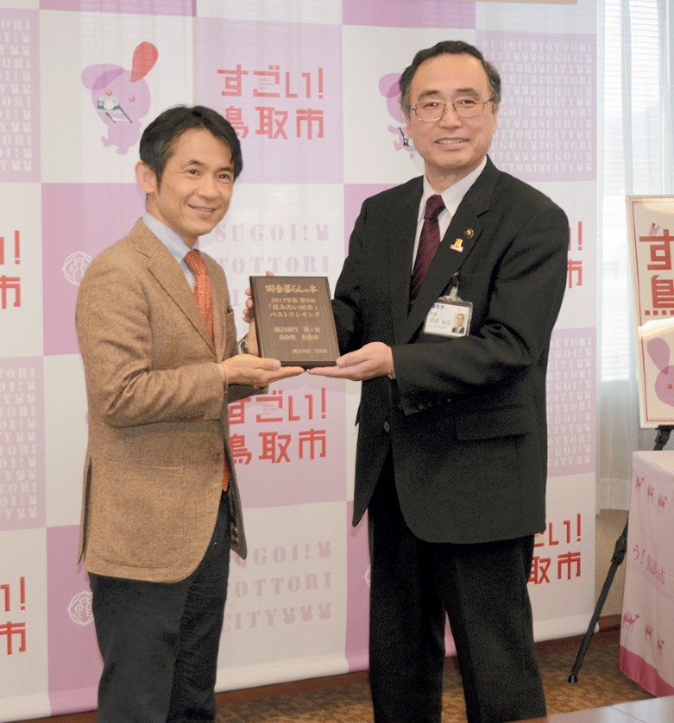 深沢義彦市長(右)に記念盾を贈る柳順一編集長
