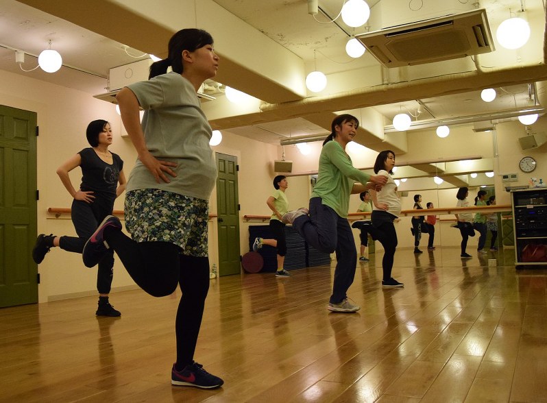 しっかり食べ、血の巡りをよくする運動で胎児の発育を促す妊婦たち=東京都世田谷区奥沢のハイハットスタジオで